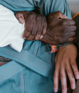 Detailed close-up of a jiu jitsu technique with hands gripping a gi, showcasing martial arts discipline.